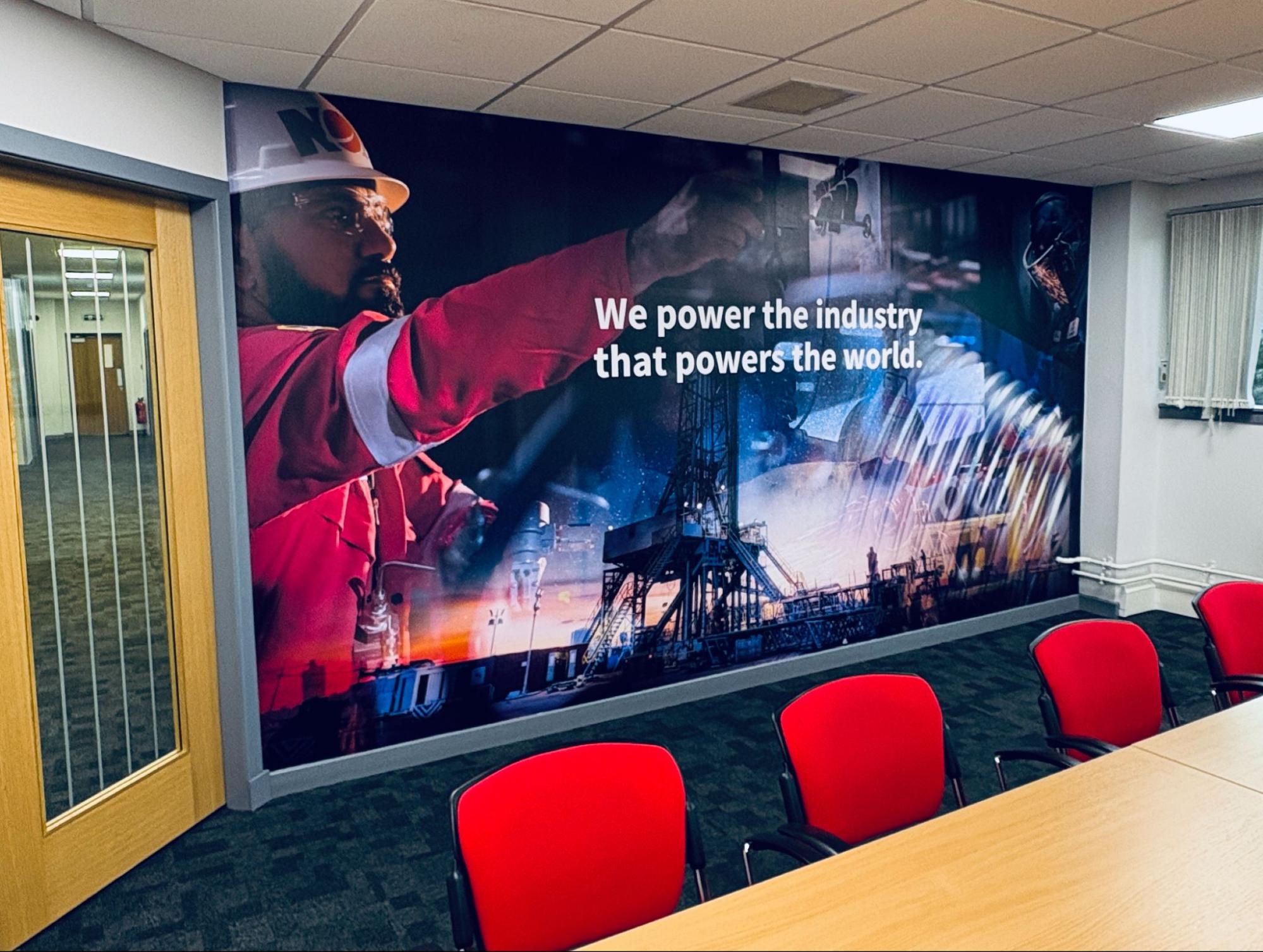 NOV wall print of oil and gas environment reading "We power the industry that powers the world".