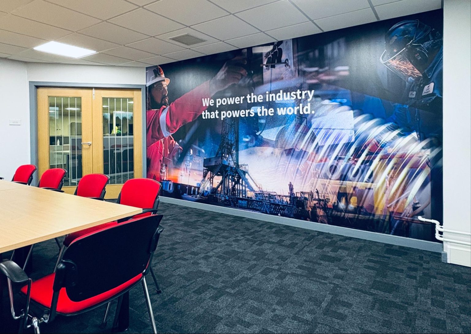 NOV wall print of oil and gas environment reading "We power the industry that powers the world".